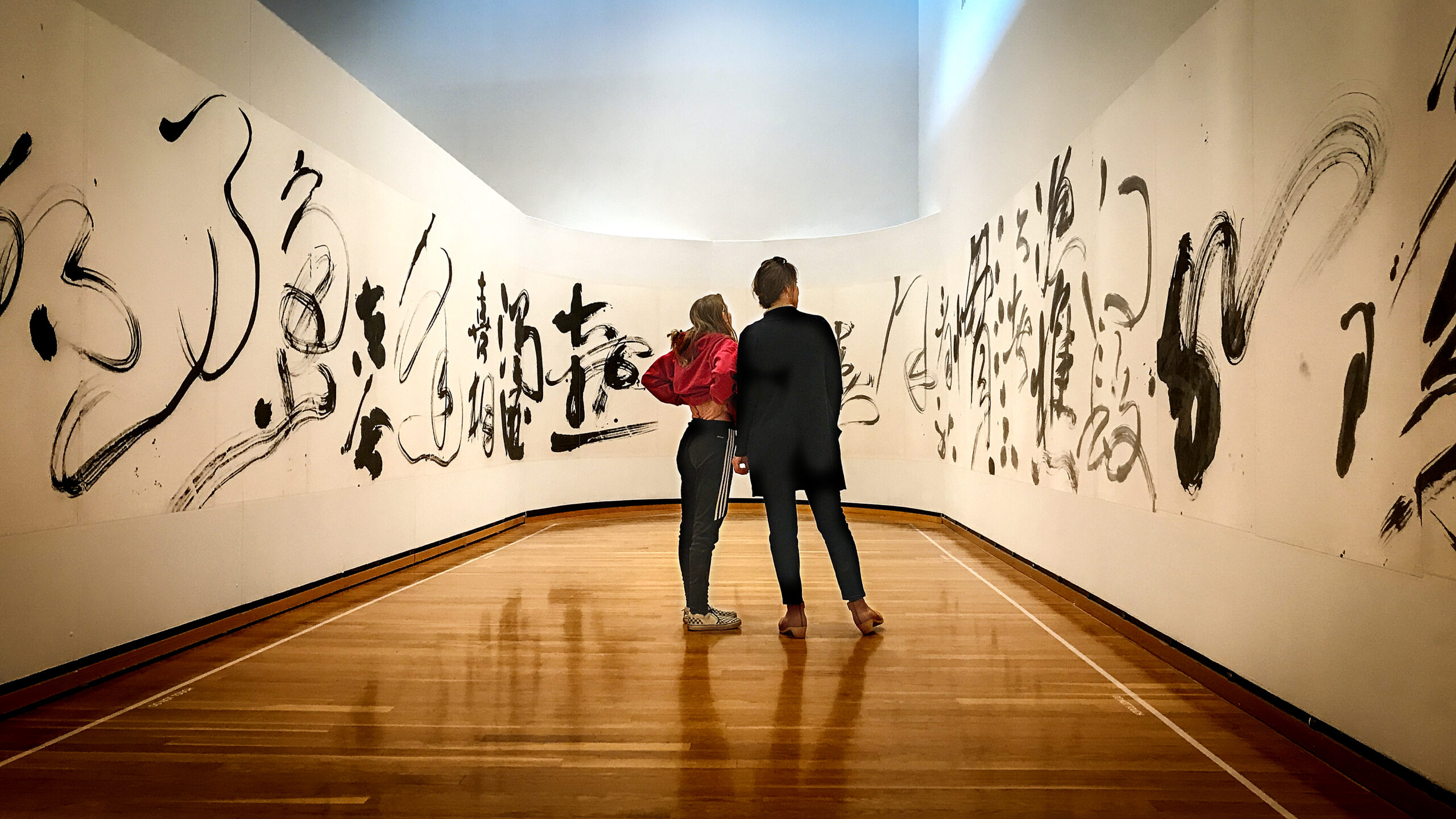 Visitors to the Herbert F. Johnson Museum of Art take in the Immortal at the River, a 54-meter-long cursive-script calligraphy work by Tong Yang-Tze.