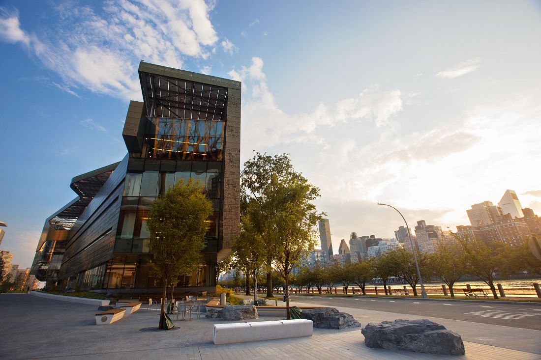 The Bloomberg Center at Cornell Tech (TECH), with the sun rising over the Manhattan skyline.